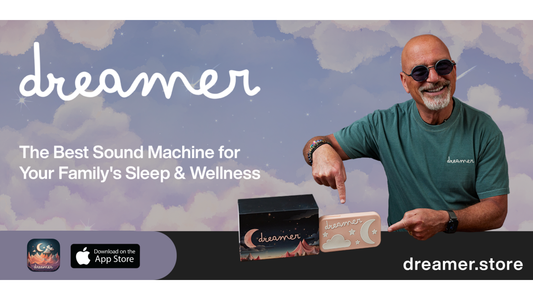 Smiling man in sunglasses points to a Dreamer baby sound machine against a dreamy sky background.