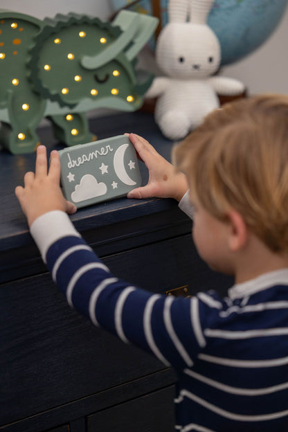 Toddler holding a Dreamer™ baby sound machine — the Duo bundle is designed for newborns through age 4